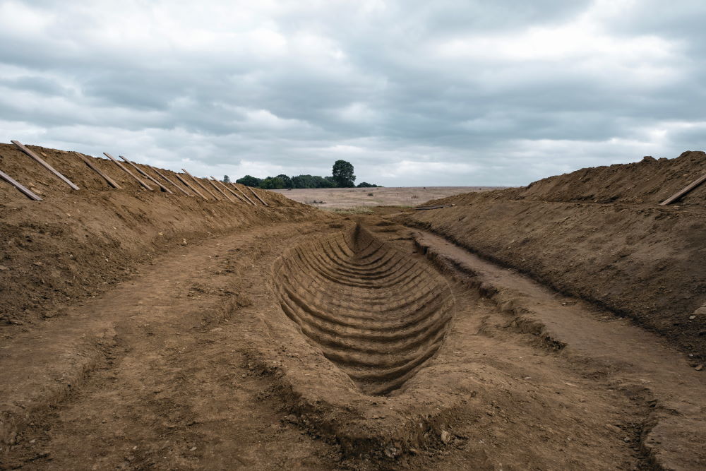 A recreation of the Sutton Hoo excavation and the imprint of the ship as it appears in The Dig.